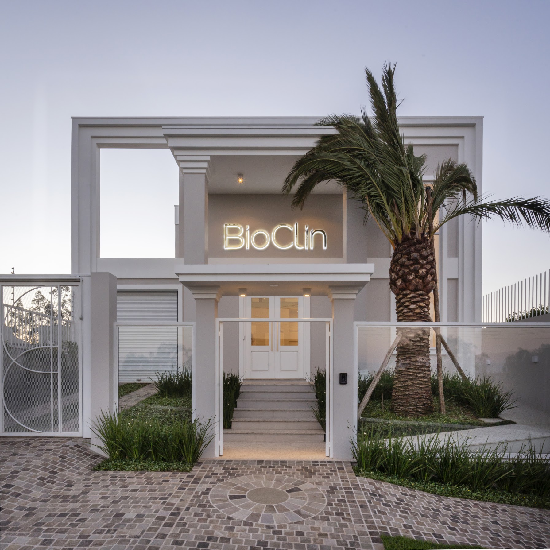 Fachada da Clínica Bioclin à noite, com iluminação e identidade da marca