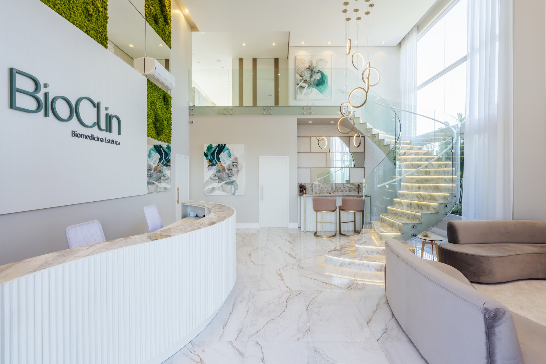 Recepção da Clínica Bioclin com a marca na parede e escada iluminada